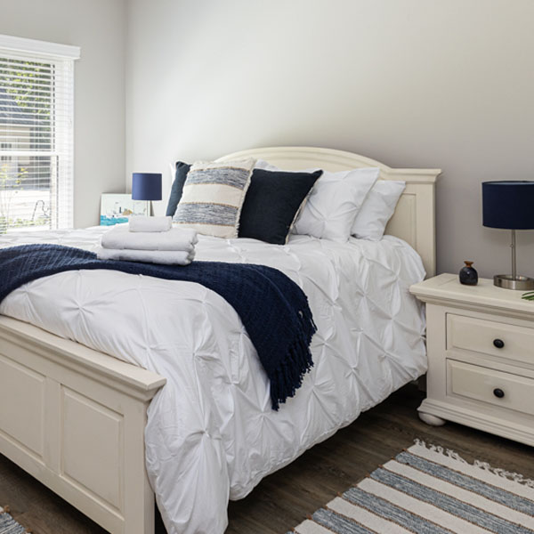 A queen-size bed in The Blue Room at The Nest at Swan Point airbnb vacation rental in Colonial Beach, Virginia.